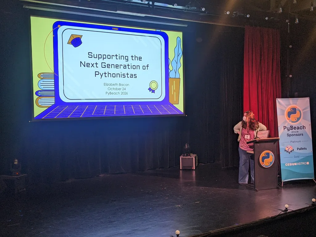 Elizabeth Bacon on stage with her title slide, 'Supporting the Next Generation of Pythonistas'