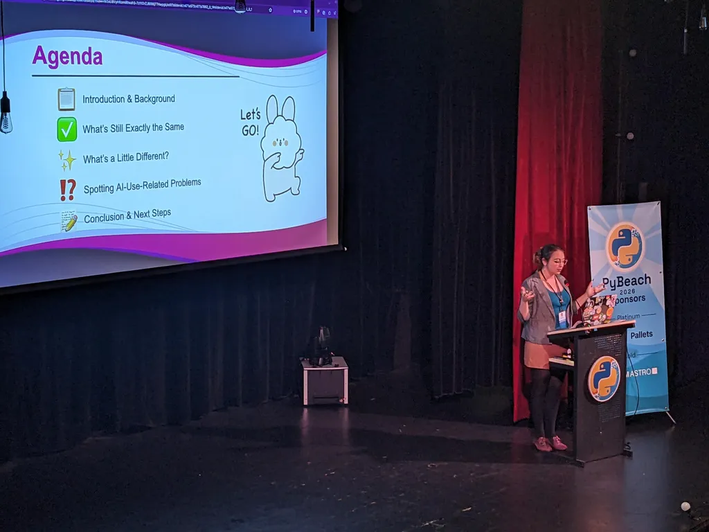 Maggie Fero on stage with their agenda slide