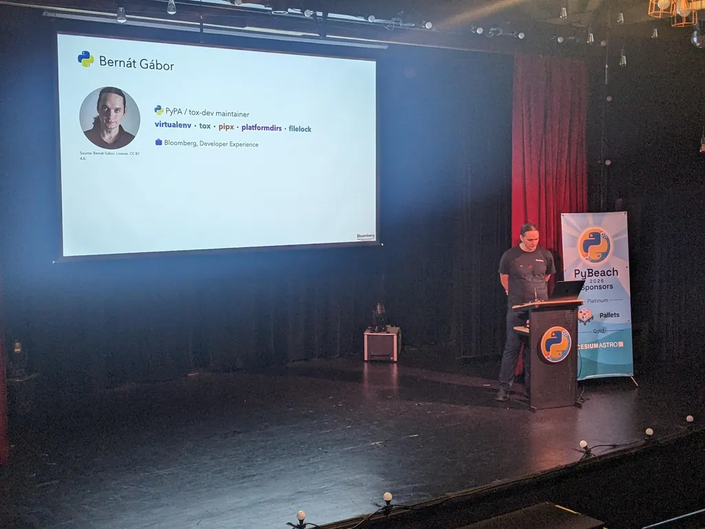 Bernát Gábor on stage with his intro slide listing virtualenv, tox, pipx, platformdirs and filelock